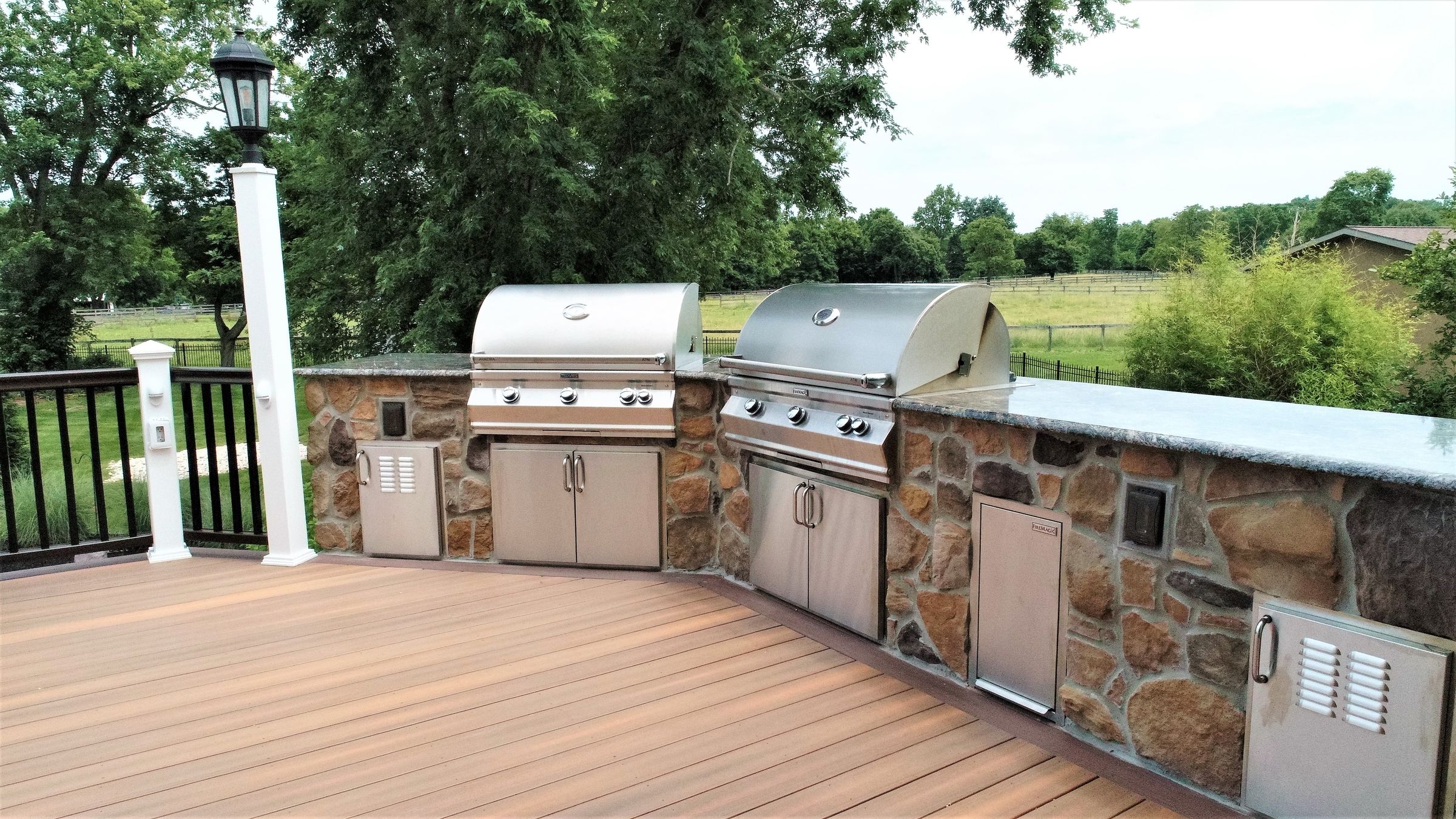 Composite deck with a built-in stone outdoor kitchen and grill