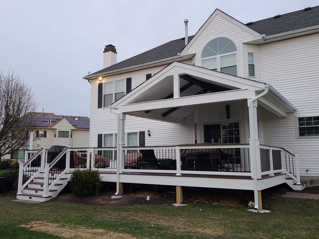 Rear of a home with a covered deck and stairs