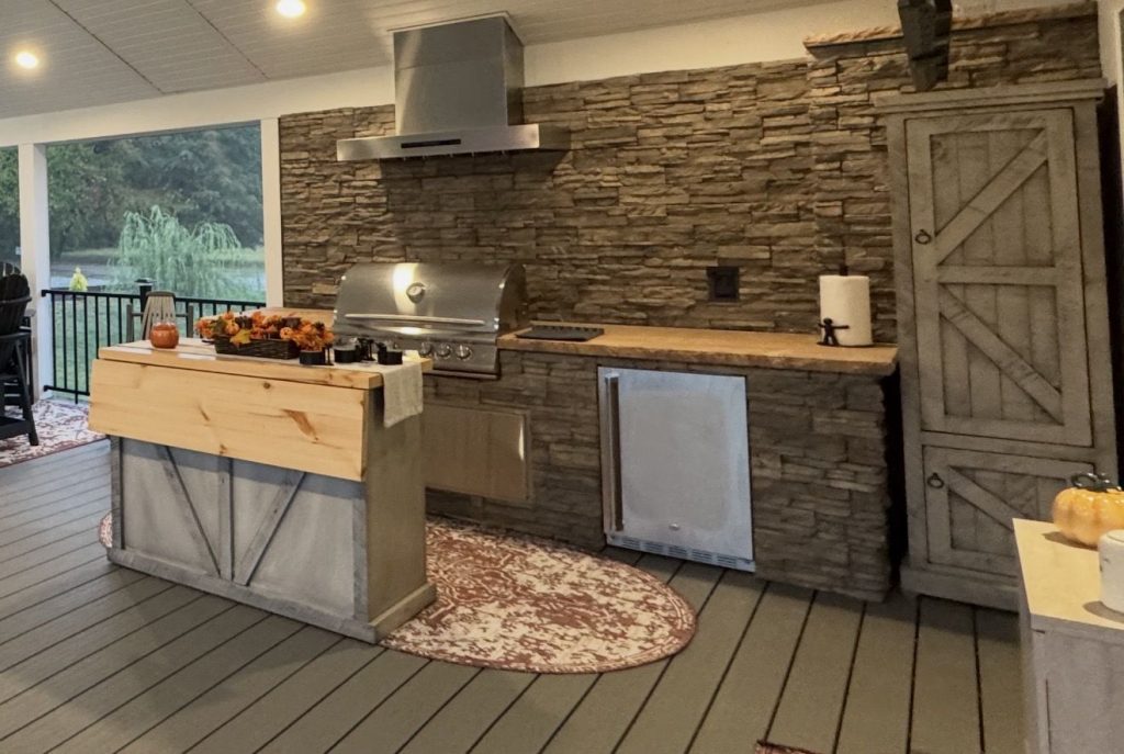 Covered porch with an outdoor kitchen, ceiling fan and lounge area