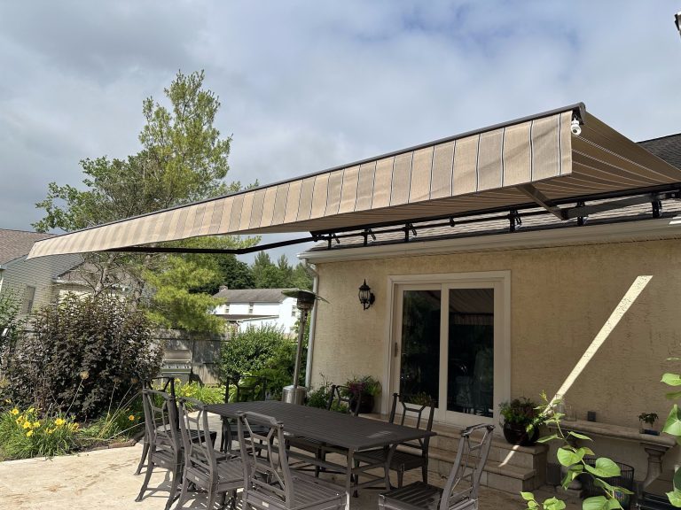 Retractable awning shading a backyard patio and outdoor dining table