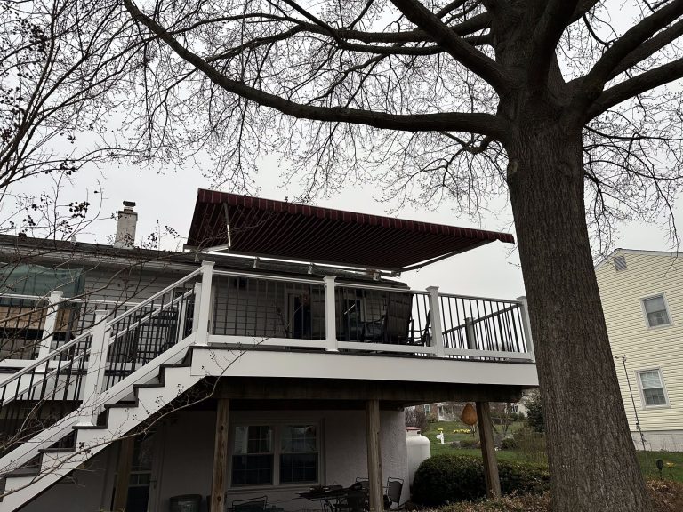Burgundy retractable awning over a second-story deck