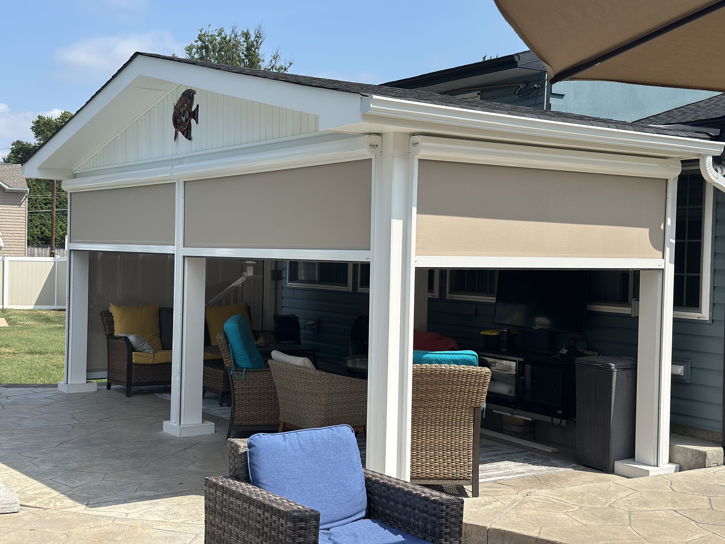 Retractable screens partly raised on a pavilion with outdoor seating