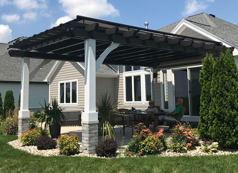 Dark roof structure with stone-clad columns over a patio