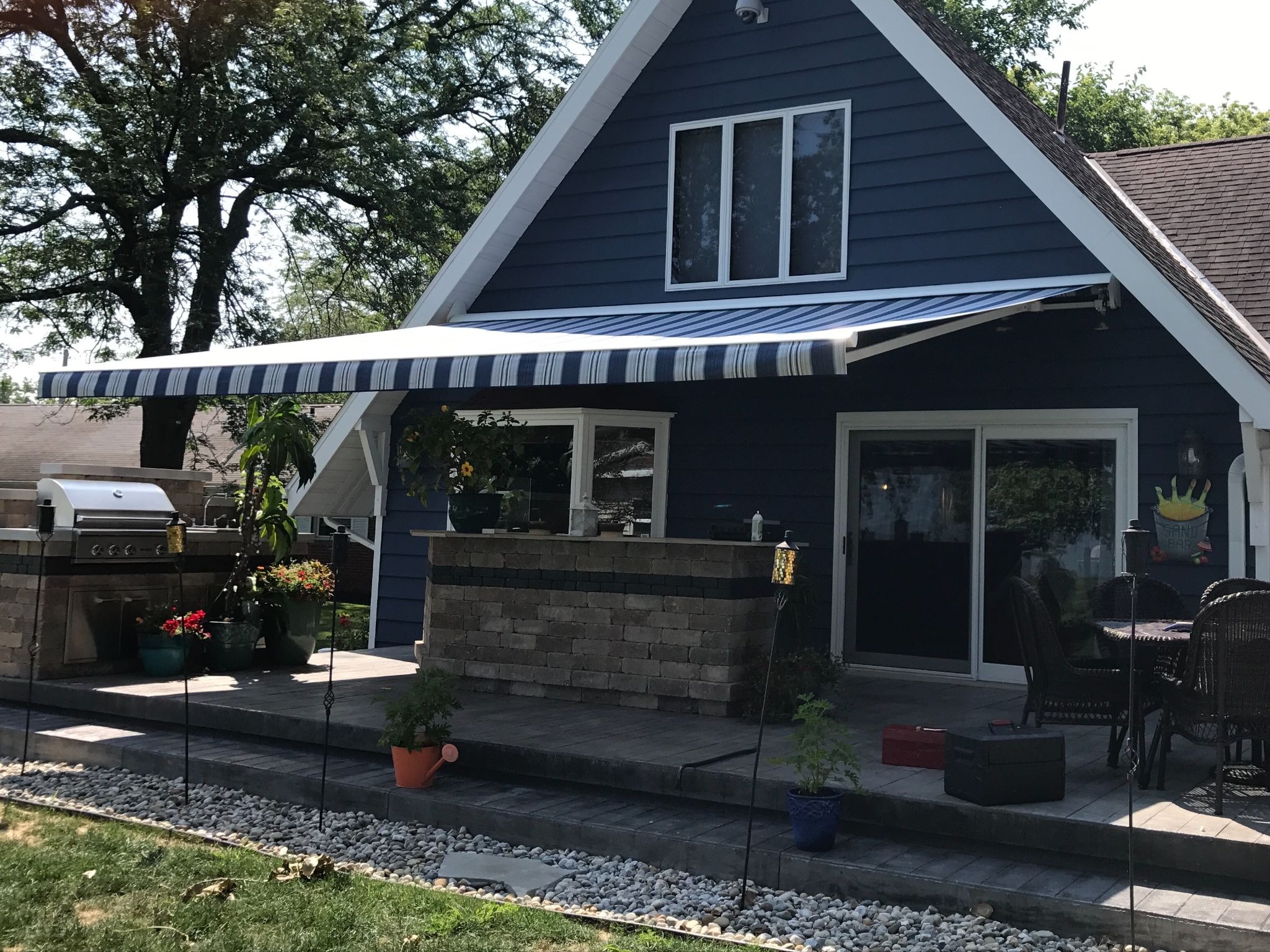 A blue Sunesta awning providing ample shade for a Pennsylvanian backyard patio.