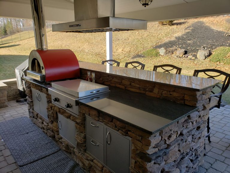 Stone outdoor kitchen bar under a covered patio